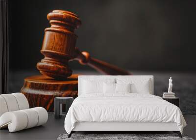 A wooden judge's gavel resting on a sound block on a gray surface with a dark background. Wall mural