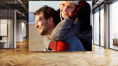 Cute couple in vacation on the beach during winter season Wall mural