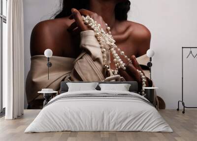 Afro American woman wearing beige trench and posing for camera in studio. Wall mural