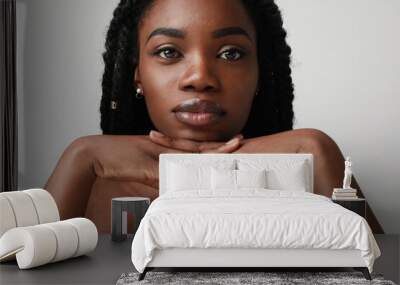 Close-up portrait of young black attractive woman, posing over white background. Skin care concept. Wall mural