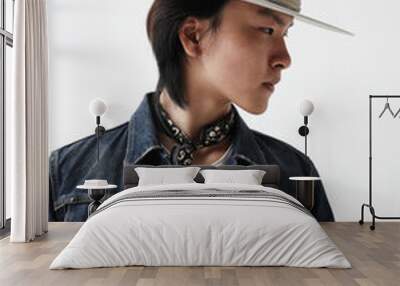 Vertical portrait of confident young Asian man wearing hat posing indoor over white background.  Wall mural