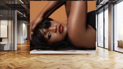 Young African American female model posing at the studio. Isolated. Wall mural