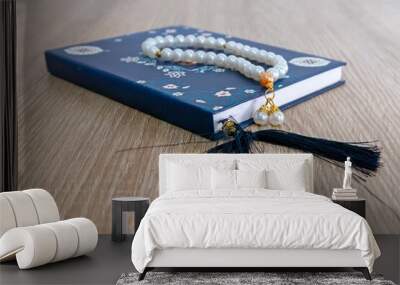 A Surah Yaseen or Yasin book and prayer beads on a wooden table Wall mural