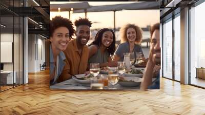 group of friends having dinner at restaurant on sunset Wall mural