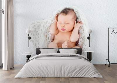 Sleeping newborn baby boy lies  in a knite plaid Wall mural