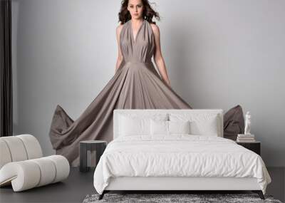  Portrait of a pretty brunette girl wearing a long silver evening gown, full length standing pose against a studio background. Wall mural