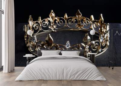 close up of a g beautiful real golden crown, isolated on dark black studio background. Wall mural