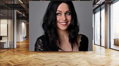 Close up portrait of a pretty, goth girl with dark hair  posing in front  a studio background. Wall mural