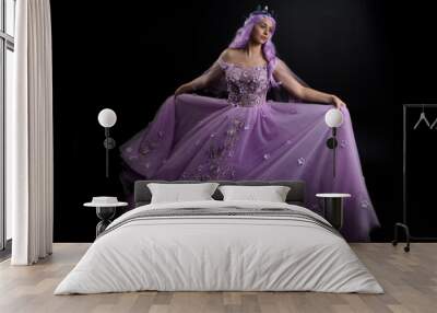 Close up portrait of girl wearing long purple fantasy ball gown with butterfly crown and pink hair, against a  dark studio background.
 Wall mural