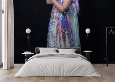 Full length portrait of beautiful female model with long purple hair wearing elf ears, a fantasy fairy crown and  rainbow glitter sequin ball gown. graceful standing pose,  isolated in dark studio bac Wall mural