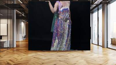 Full length portrait of beautiful female model with long purple hair wearing elf ears, a fantasy fairy crown and  rainbow glitter sequin ball gown. graceful standing pose,  isolated in dark studio bac Wall mural