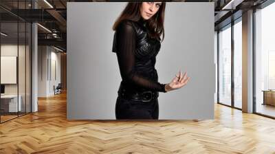 portrait of a pretty brunette woman wearing black leather fantasy costume  on a studio background. Wall mural