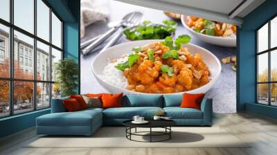 Cauliflower curry with peanuts and cilantro in a bowl Wall mural