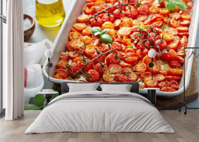 Cherry tomatoes roasted with garlic and spices on a baking tray Wall mural