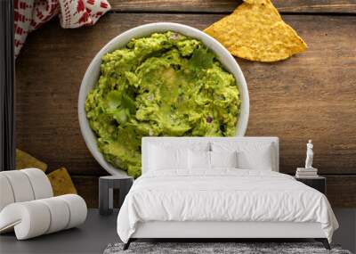 Chunky homemade guacamole in a bowl with tortilla chips Wall mural