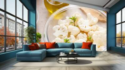 Raw cauliflower florets in a glass bowl, ready to roast with spices and olive oil Wall mural