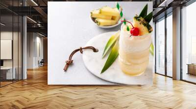 Tropical tiki cocktail pina colada in a fun glass garnished with pineapple Wall mural