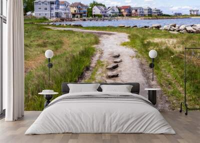 Coastal gravel road with the small seaside neighborhood on the background in East Greenwich, Rhode Island Wall mural