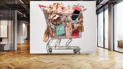 Shopping trolley full of fashion shopping items isolated on white background without people Wall mural