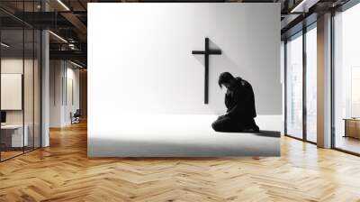 Man praying in front of a cross with copy space Wall mural