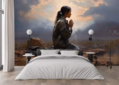 Woman soldier praying in the desert with mountains and clouds in the background Wall mural