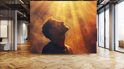 Young man praying in the smoke on the background of the rays of the sun. Worship. Wall mural