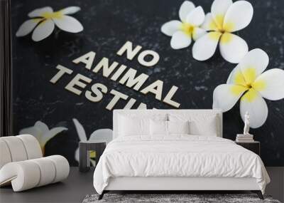 cruelty-free beauty, No Animal Testing message among flowers on black marble desk Wall mural