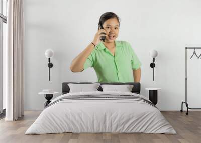 Young Asian female nurse making a phone call via cell phone with a happy expression, concept of health treatment and work with dedication, isolated white background.
 Wall mural