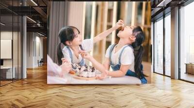 Two children eat a fresh cake together for their birthday Wall mural