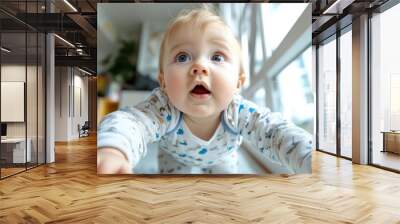 A close-up shot of a curious baby crawling on the floor indoors, surrounded by bright natural light, representing innocence and the spirit of exploration. Wall mural