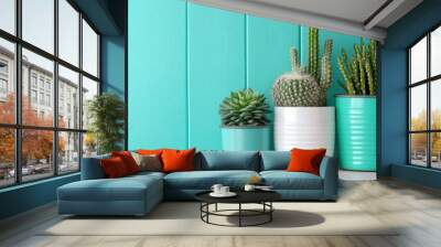 A collection of three potted plants placed against a vibrant turquoise wall, showcasing diverse sizes and shapes, conveying modern home decor aesthetics. Wall mural