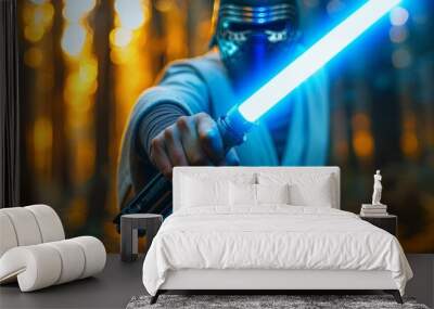 An intense portrayal of a person with an iconic blue lightsaber extended towards the camera in a natural setting Wall mural