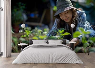 Woman engaged in gardening, planting young seedlings Wall mural