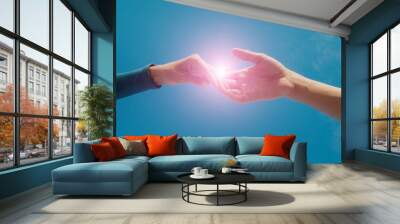 Female and male hands reaching to each other on sky background. Help and care concept Wall mural