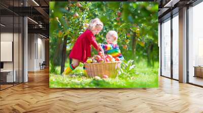 Adorable kids picking apples in a garden Wall mural