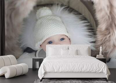 adorable smiling little baby sitting in a warm stroller Wall mural