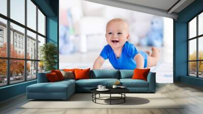 Baby boy playing and learning to crawl Wall mural