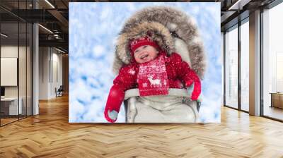 Baby in stroller in winter park with snow Wall mural