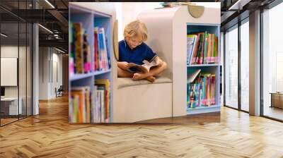 Child in school library. Kids reading books. Wall mural