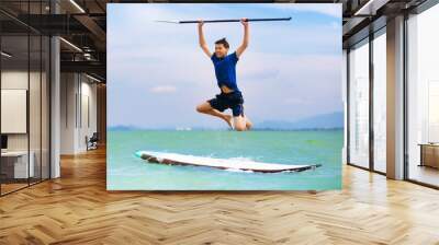 Child on stand up paddle. Water and beach sport Wall mural