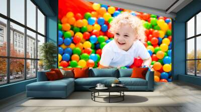 Child playing in ball pit on indoor playground Wall mural