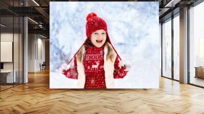 Child playing in snow on Christmas. Kids in winter Wall mural