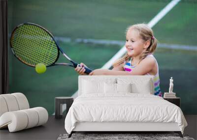 Child playing tennis on outdoor court Wall mural