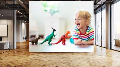 Child playing with toy dinosaurs. Kids toys. Wall mural