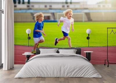 Child running in stadium. Kids run. Healthy sport. Wall mural