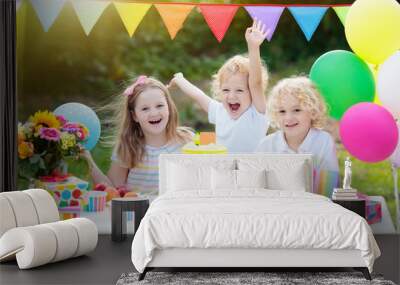 Children blow candles on birthday cake. Kids party Wall mural