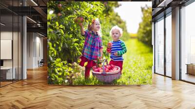 Kids picking apples in fruit garden Wall mural