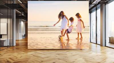 Kids play football on tropical beach at sunset Wall mural