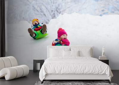 Kids play in snow. Winter sled ride for children Wall mural