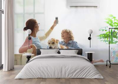 Mother and child with air conditioner remote Wall mural